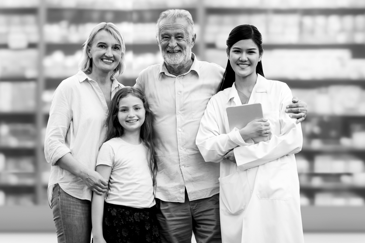 Großvater, Mutter und Tochter stehen mit einer Mitarbeiterin in der Apotheke.