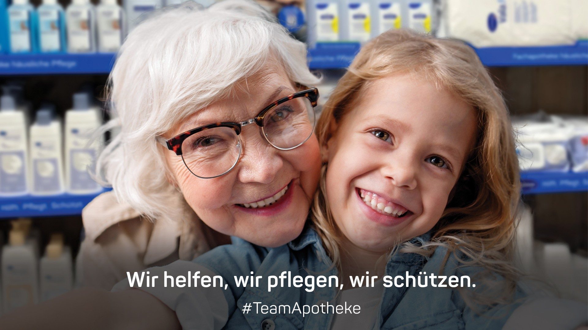 PHAT Apothekentour Headerbild Wir helfen, wir pflegen, wir schützen. Oma und Enkeltochter in fester Umarmung und lächelnd in einer Apotheke.